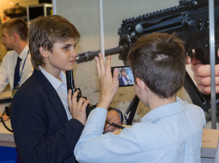 Kiev, Ukraine - September 22, 2015: Boy posing with a gun at the specialized exhibition Arms and...