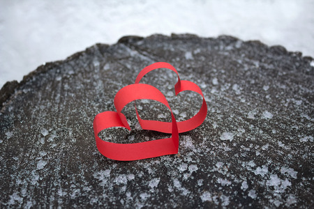 Two red hearts made of paper on a wooden surface. Love