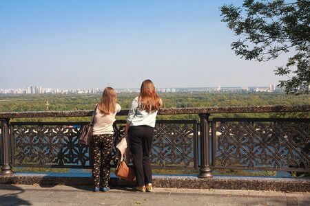 Kiev, Ukraine - September 18, 2015: Girls tourists watching the panorama of the city from the observation platformのeditorial素材