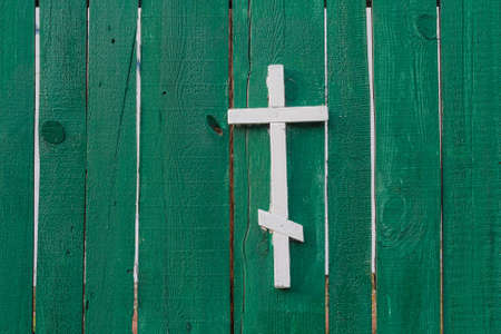 White cross on green wooden fence. Religionの写真素材