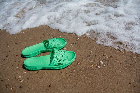 Green slippers lie on the seashore. Recreationの写真素材
