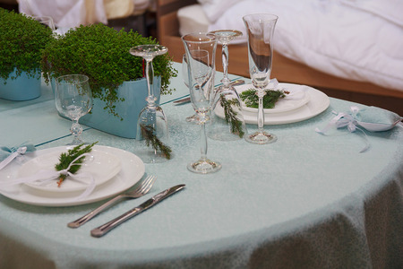 Christmas table setting with glasses of fir branchesの写真素材