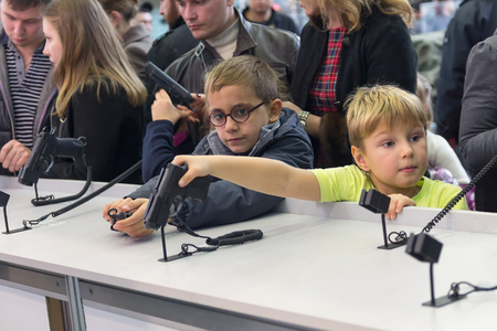 Kiev, Ukraine -October 14, 2016: Children see a gun at the exhibition "Arms and Security - 2016"のeditorial素材