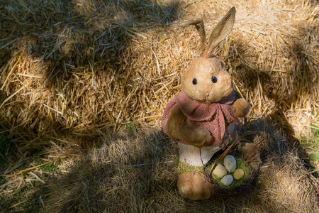 Toy rabbit with Easter eggs in the yardの写真素材