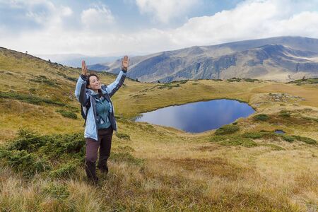 Girl tourist in the mountains emotionally gesticulates. Peopleの写真素材
