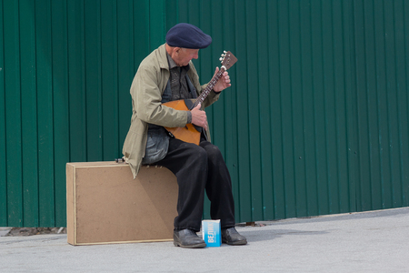 Kiev, Ukraine - May 03, 206:  An elderly man makes a living playing a balalaikaのeditorial素材