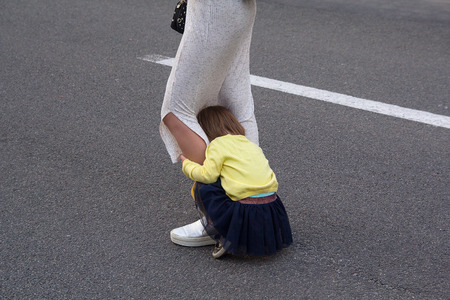 Little girl hides behind her mother's legs. Peopleの写真素材