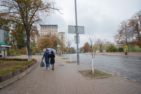 Kiev, Ukraine - September 08, 2016: Couple under an umbrella on an empty street Institutskayaのeditorial素材