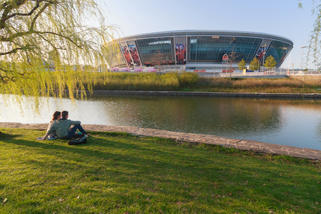 Donetsk, Ukraine - April 29, 2017: Young couple is resting in a park near the Donbass Arena Stadiumのeditorial素材