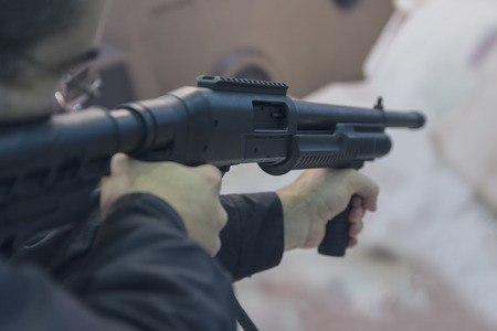 Man is aiming from a shotgun close-up. Weapons