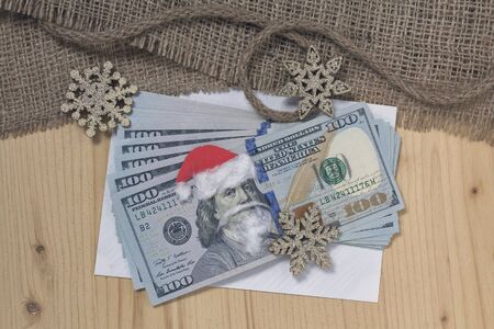 Benjamin Franklin in a Santa Claus hat on a bill and background in retro style. Christmas decorationsの写真素材