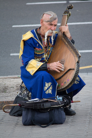Kiev, Ukraine - June 19, 2016: Elderly kobzar in a national costume plays a kobza on the streetのeditorial素材