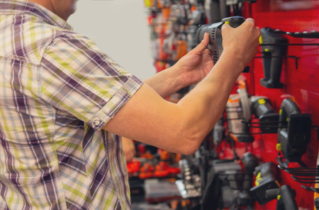 Man chooses electric the tool in shop. Marketの写真素材