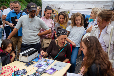 Kiev, Ukraine - September 09, 2018: Fortune-teller discovers the girl on the cards at the celebration of the day of the St. Andrew's Descent - the historical part of the cityのeditorial素材