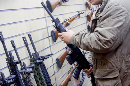 Man with an automatic rifle at the store. Weapons