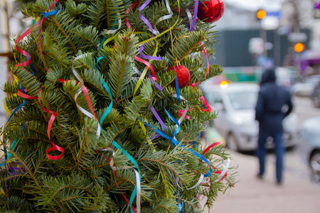Decorated Christmas tree and pedestrians on a city streetの写真素材
