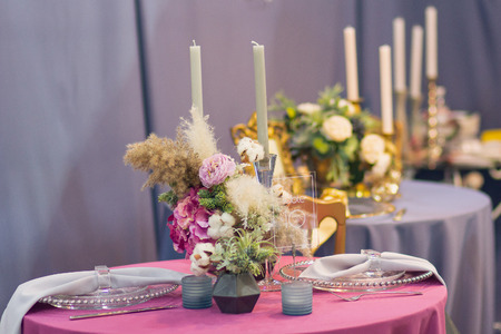 Beautiful table set with flowers and candles for a wedding dinnerの写真素材