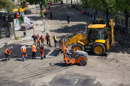 Kiev, Ukraine - May 12, 2018: Workers lay mastic on asphalt during street repair work