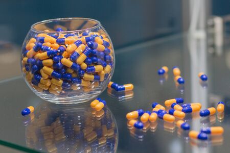 Heap of various tablets on a glass show-window. Medicine and pharmacology