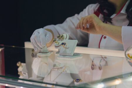 Seller shows the jewelry at the counter. Sales