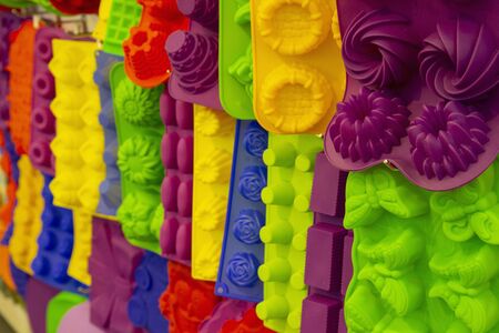 Silicone bakeware different colors and forms hang on the shelf of the storeの写真素材