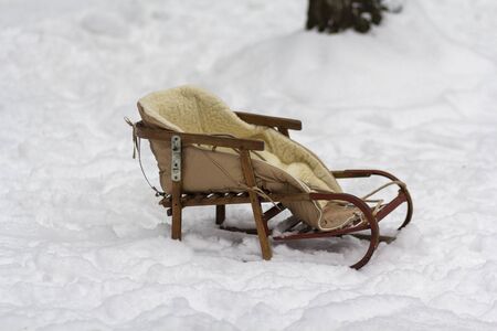 Retro wooden sleigh in the snow in the park