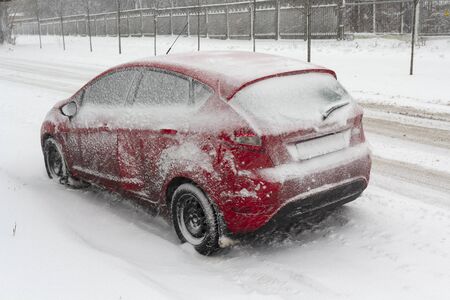 Red car, covered with thick layer of snowの写真素材
