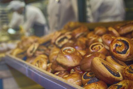 Buns on the counter and baker in the bakery. Food