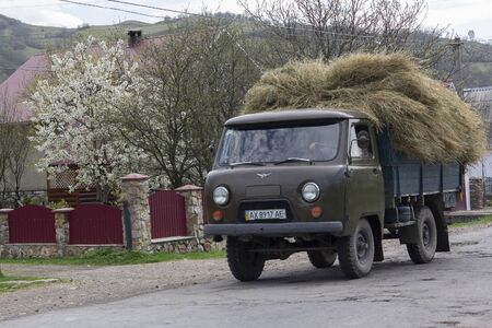 Carpathians, Ukraine - April 18, 2017: Truck laden with hay drives through the villageのeditorial素材