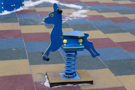 Swing on a spring on an empty playgroundの写真素材