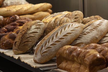 Batch of fresh baked buns and loafs on a market counter . Bread manufactureの写真素材