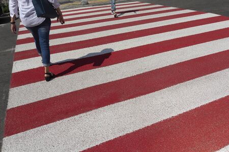 Red and white lanes and pedestrian legsの写真素材