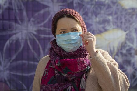 Serious woman in a protective mask on a city street. Peopleの写真素材