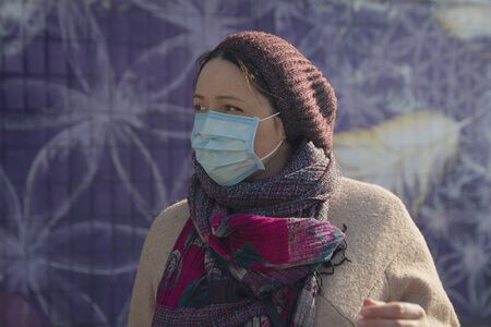 Serious woman in a protective mask on a city street. Peopleの写真素材