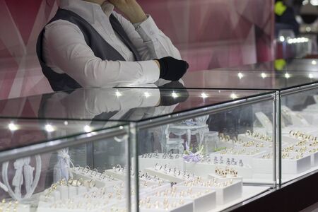 Girl near a counter salesman in a jewelry store. Saleの写真素材