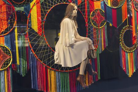 Female mannequin sitting and looking in the window of a luxury shop. Saleの写真素材