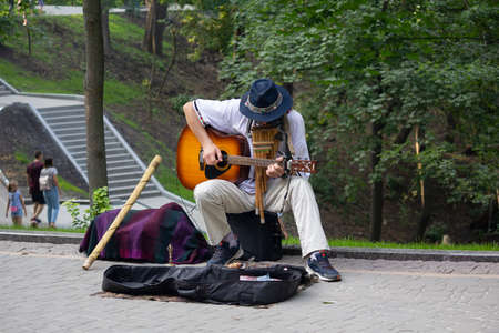 Kiev, Ukraine - July 28, 2019: Street musician plays guitar in the city park