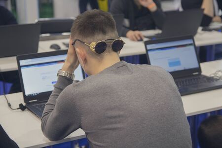 Young man in front of laptop during testing. Educationの写真素材