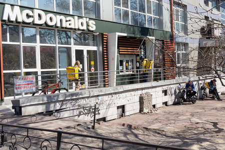 Kiev, Ukraine -April 06, 2020: Couriers and delivery services Glovo in the queue near the McDonald's. Ukraine stops bars, restaurants and shopping centers, to stop the spread of the coronavirus.のeditorial素材