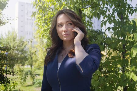 Beautiful business woman talking on a smartphone in the park. Peopleの写真素材
