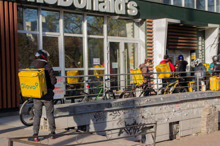 Kiev. Ukraine - April 12, 2020: Couriers and delivery services Glovo in the queue near the McDonald's. Ukraine stops bars, restaurants and shopping centers, to stop the spread of the coronavirusのeditorial素材