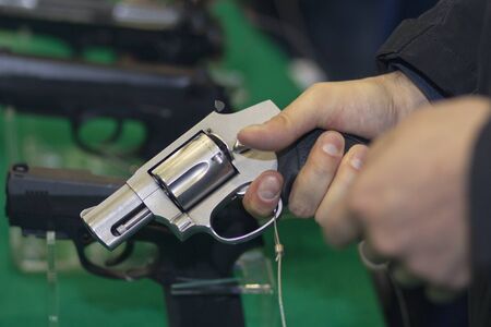 Pistol gun in the hand of the buyer at the store weaponsの写真素材