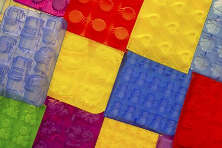 Silicone bakeware different colors and forms hang on the shelf of the store