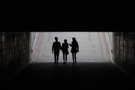 Silhouettes of young people in the underpass. Peoplesの写真素材