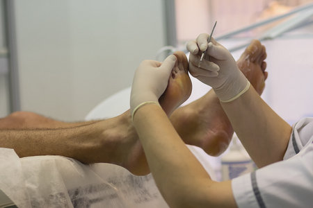Beautician doing hardware pedicure for male clientの写真素材