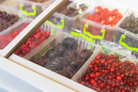 Frozen berries and fruits on a store counter close-up. Foodの写真素材
