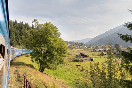 View from the train window at the sunlit village. Carpathians, Ukraineの写真素材