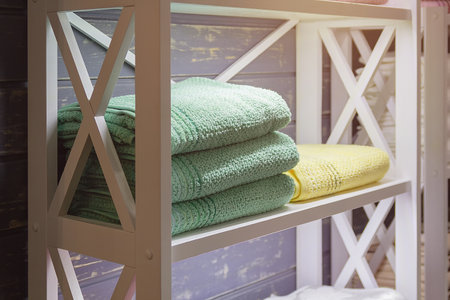 Towels lie on a wooden rack in a retro style bathroomの写真素材