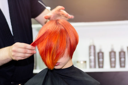Hairdresser do a beautiful hairstyle for a bright girl. Hairdressing artの写真素材