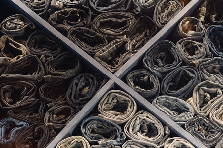 A stack of various folded jeans in a clothing store window. Backgroundの写真素材